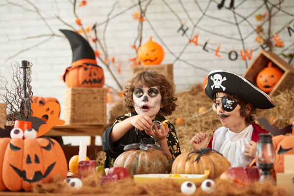 Children enjoying making halloween decorations for party together