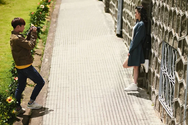 Jovem Tirando Foto Sua Namorada Contra Bela Parede Livre — Fotografia de Stock