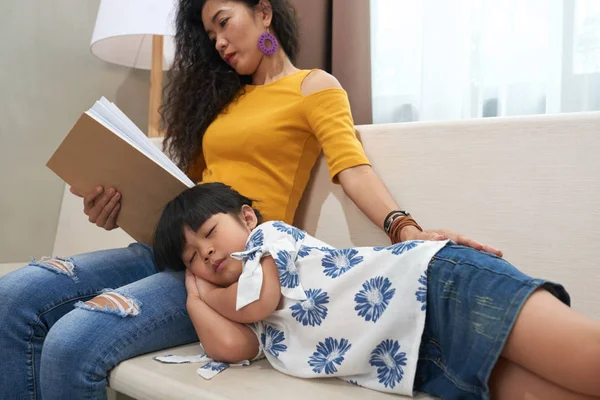 Jovem Mulher Lendo Livro Quando Sua Filha Está Dormindo Joelhos — Fotografia de Stock