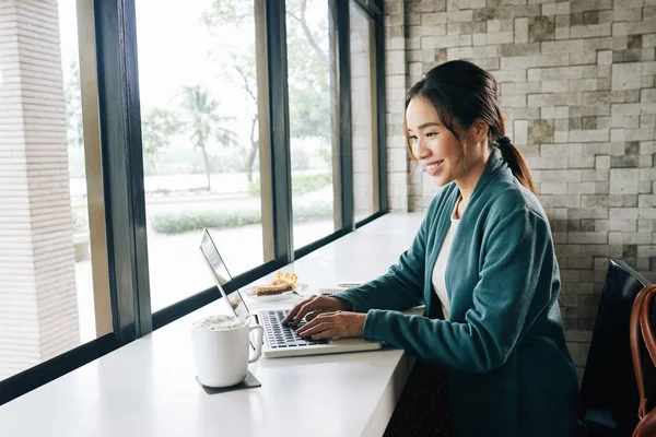 Schöne Junge Asiatische Frau Sitzt Fenster Café Und Arbeitet Laptop — Stockfoto