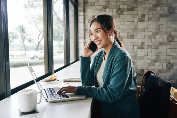 Schöne Lächelnde Geschäftsfrau Telefoniert Und Arbeitet Laptop Café — Stockfoto