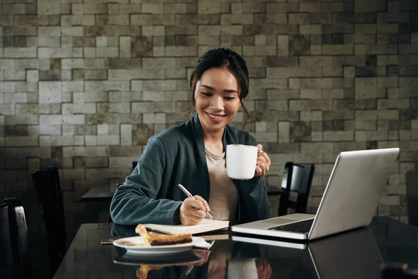 Lächelnde Hübsche Vietnamesische Junge Frau Trinkt Kaffee Und Schreibt Pläne — Stockfoto