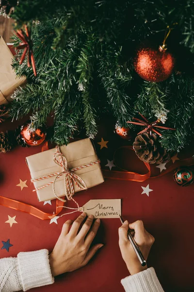 Femme Écrivant Joyeux Noël Sur Étiquette Cadeau — Photo