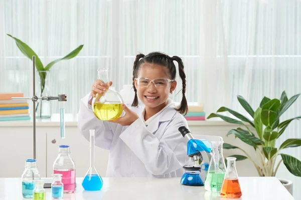 Gelukkig Schoolmeisje Holding Kolf Met Gele Reagens — Stockfoto