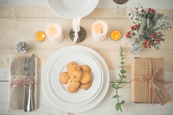 盘子和曲奇饼和礼物在桌上为圣诞节晚餐服务 — 图库照片