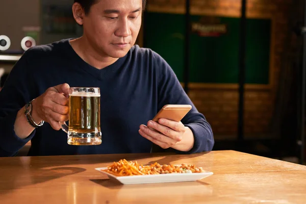 Vietnamien Mature Homme Boire Bière Lire Des Nouvelles Dans Smartphone — Photo