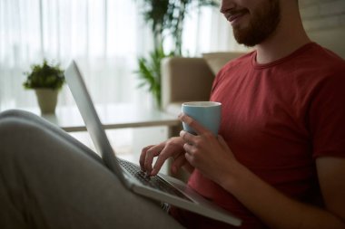 Dizüstü bilgisayarda çalışan kahve fincanı ile adamın Resim kırpılmış