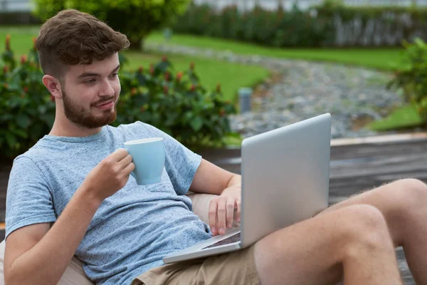 Leende Ung Man Dricka Kaffe Och Arbetar Laptop Utomhus — Stockfoto