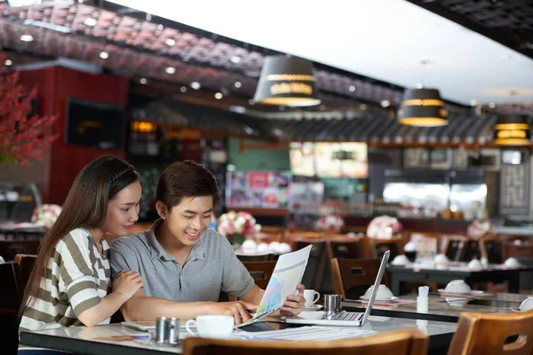 아시아 부부는 지도의 도움으로 현대적인 카페를 — 스톡 사진