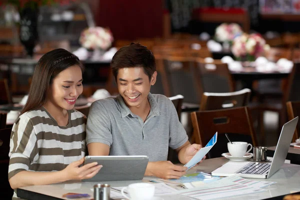 陽気なアジア カップル デジタル タブレットでカフェに座って ホテルを予約し 航空会社のチケットをオンライン購入 — ストック写真