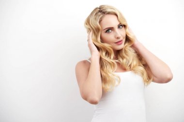 Dalgalı sarı saçlı beyaz arka planı şirin poz ile güzel genç kadın portresi