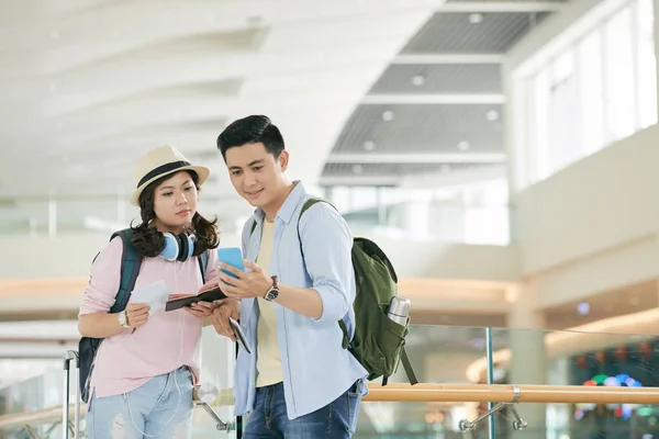 越南青年夫妇在机场候机楼检查智能手机时刻表 — 图库照片