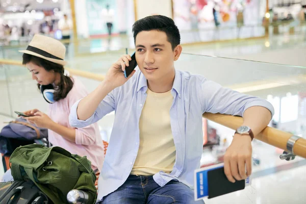 Wietnamski Młody Człowiek Siedzi Terminalu Lotniska Wywołanie Telefon — Zdjęcie stockowe