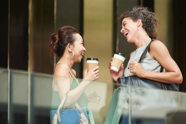 两个女人带着咖啡去聊天和欢笑 — 图库照片