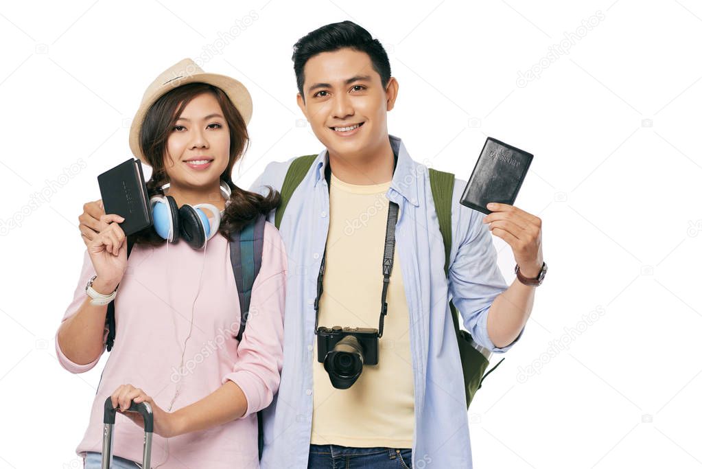 Happy Vietnamese traveling couple showing their passports