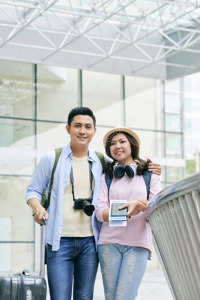 Cheerful Vietnamese couple with passports and boarding passes