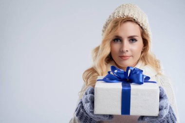 Büyük giftbox tutan bere içinde gülümseyen genç kadın portresi