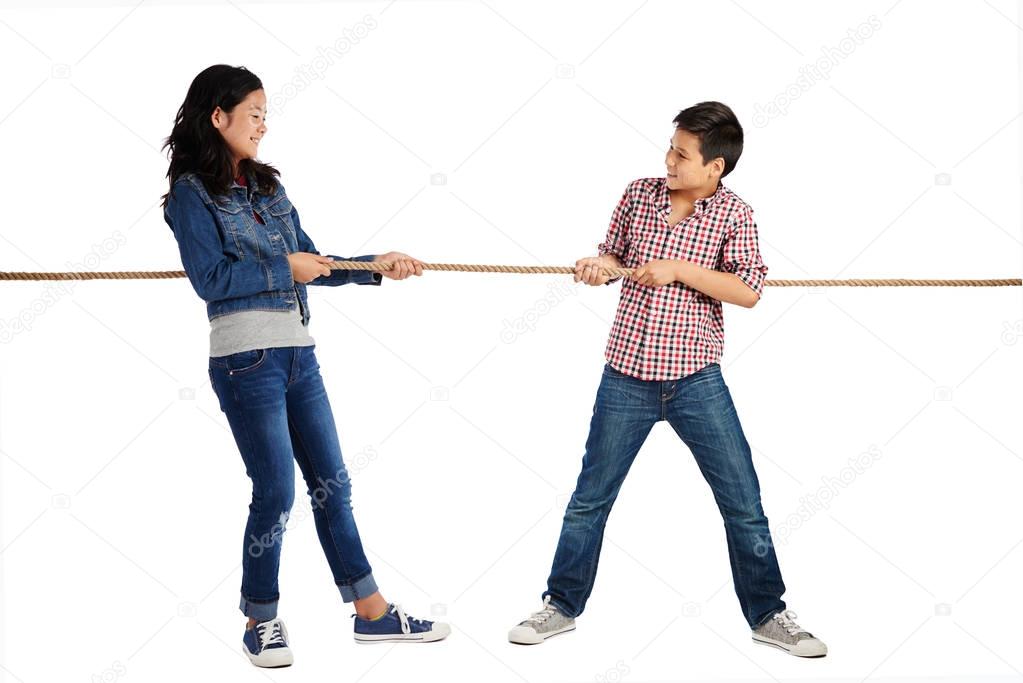 Brother and sister playing tug of war, isolated on white