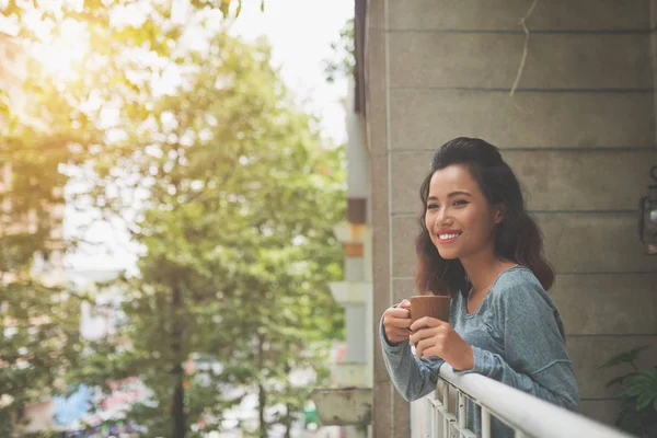 可爱的年轻的亚洲女人站在阳台上喝一杯热咖啡 — 图库照片