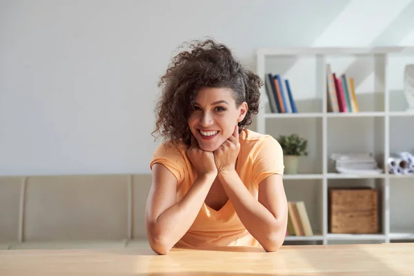 Atractiva Mujer Sonriente Sentada Mesa Mirando Cámara —  Fotos de Stock
