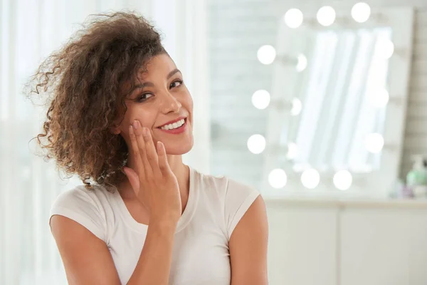 Lächelnde Junge Frau Trägt Feuchtigkeitscreme Auf Ihr Gesicht Auf — Stockfoto