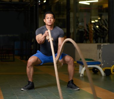 Savaş halatlar ile spor salonunda güçlü Vietnamca atlet exerising