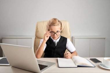 Ciddi küçük çocuk onun işyeri ofis, masa üstünde laptop