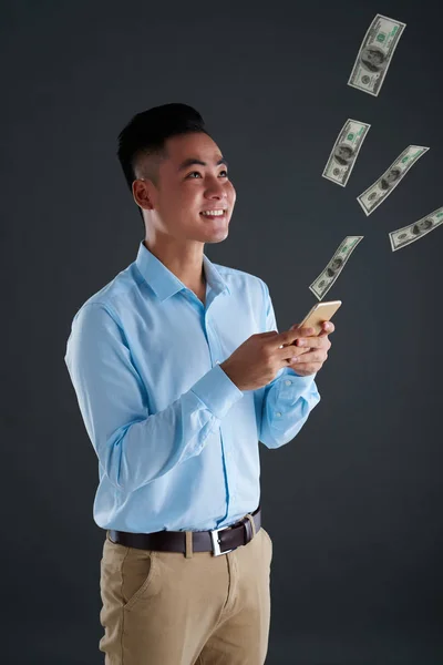 Fröhlicher Junger Mann Schaut Auf Geldfluss Der Aus Seinem Smartphone — Stockfoto