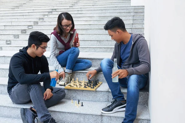 Skupina Asijských Přátel Hrát Šachy Když Sedí Schodech Venku — Stock fotografie