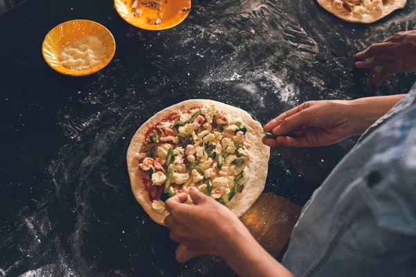 Menschenhände Die Zutaten Zur Pizza Hinzufügen Blick Von Oben — Stockfoto