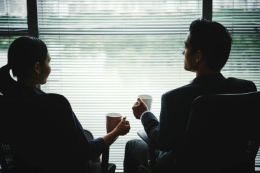 Kahve içme ve pencerede, oturup konuşurken meslektaşları görüntülemek arkadan