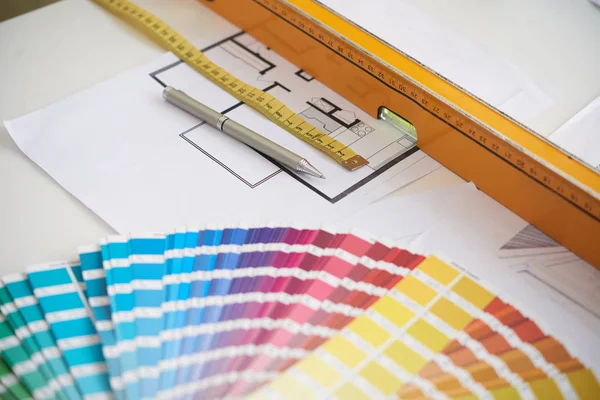 Group of objects for interior design on work  table: color swatches, floor plans and rulers, closeup background image