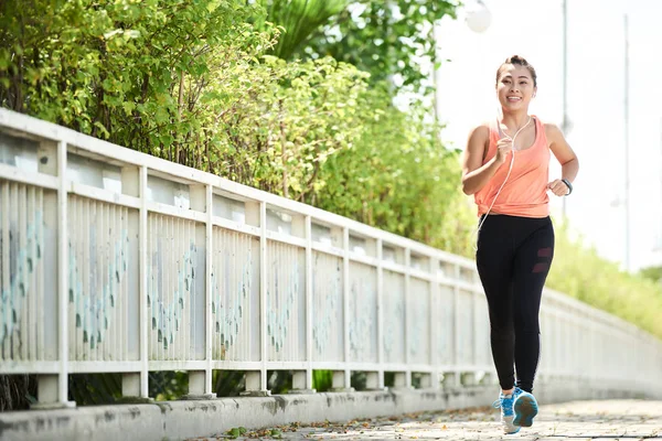 Hermosa Mujer Asiática Sonriente Escuchando Música Cuando Trota Aire Libre — Foto de Stock