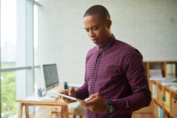 Hombre Negocios Afroamericano Sosteniendo Tableta Digital Mientras Está Pie Oficina —  Fotos de Stock