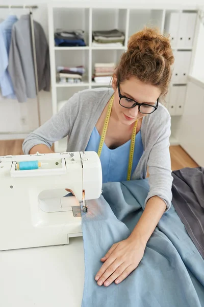 Pretty Young Female Tailor Sewing Blue Cloth — Stock Photo, Image