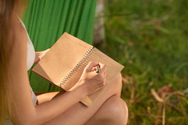 yaz günü yeşil bahçesinde harcama yaparken not alma kadın