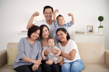 Evde fotoğraf için poz büyük Asya aile portresi: kanepede oturan