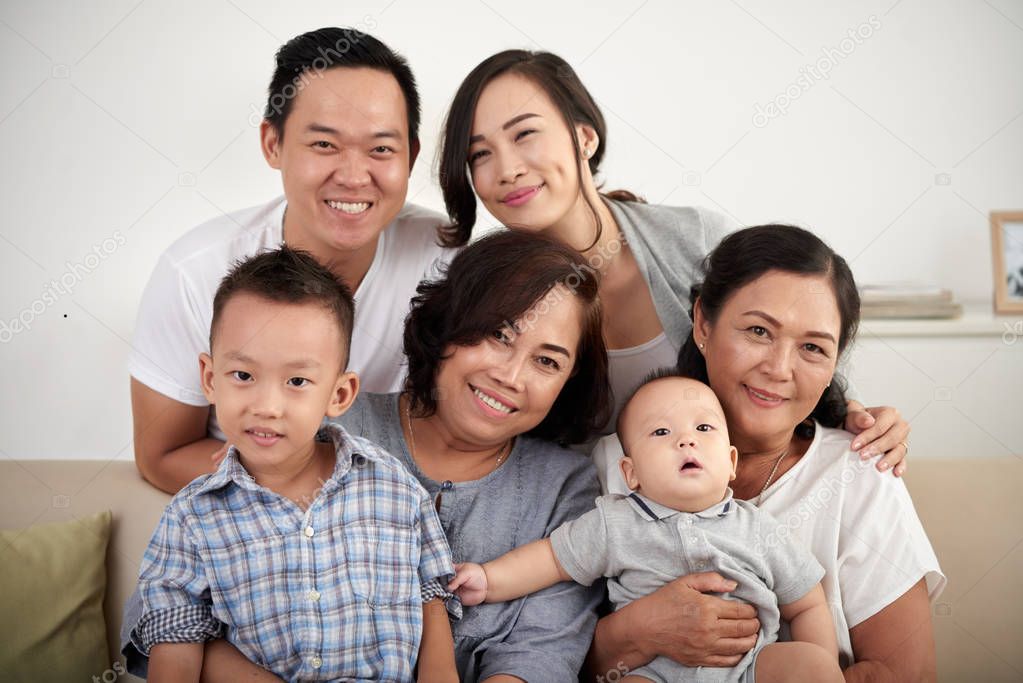 Portrait of  big Asian family with two children posing for photo at home