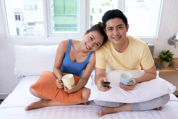 Sorridente Coppia Asiatica Bere Caffè Letto Guardare Qualcosa — Foto Stock