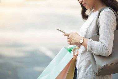 Smartphone cep telefonu ile mesaj okuma kağıt torba ile kadının Resim kırpılmış