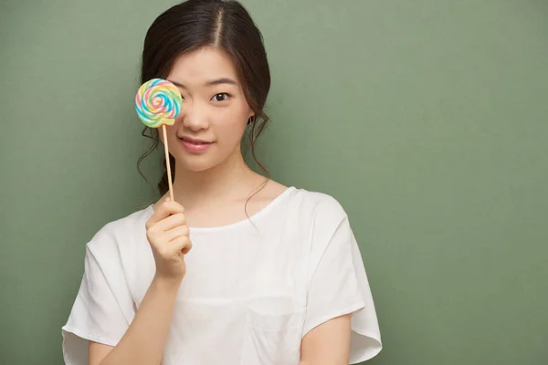 漂亮的韩国女孩用棒糖罩着她的眼睛 — 图库照片