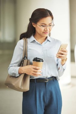 Vietnamca iş Bayan okuma mesaj smartphone cep telefonu ile gülümseyen