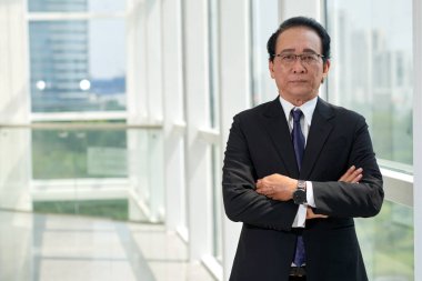 Office koridor ayakta ve kameraya bakarak emin işadamı portresi