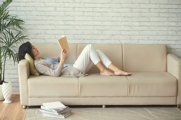 Young Woman Lying Sofa Reading Stack Books Floor Next Her — Stock Photo, Image