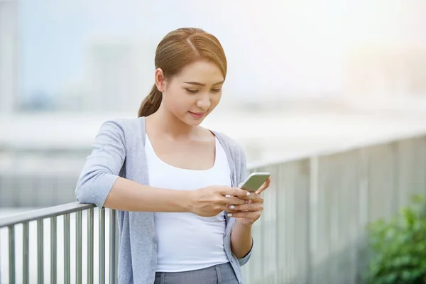 Lächelnde Junge Geschäftsfrau Nutzt Anwendung Auf Ihrem Smartphone — Stockfoto