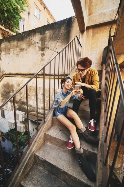 可爱的亚洲情侣坐在破旧的公寓楼和冲浪移动 — 图库照片