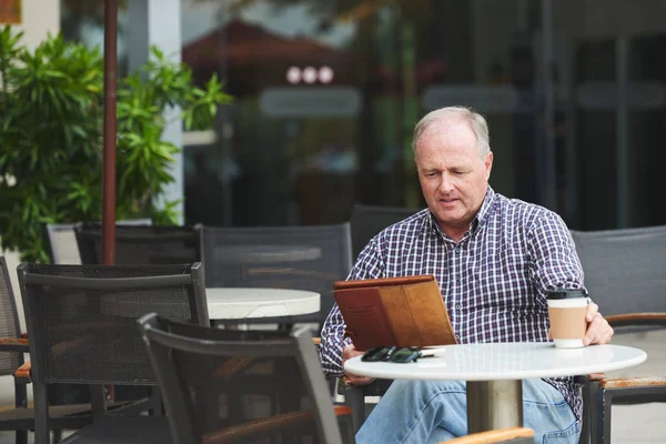 人喝咖啡和阅读新闻在平板电脑在室外咖啡馆 — 图库照片