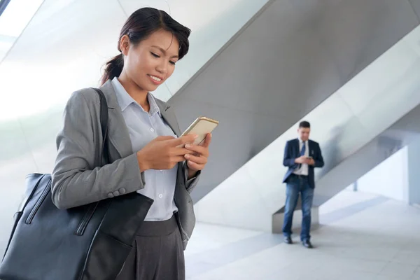 Hübsche Lächelnde Geschäftsfrau Die Nachrichten Ihren Smartphones Liest — Stockfoto