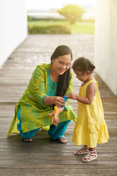 亚洲母亲和她漂亮的小女儿在夏天公园散步时吹肥皂泡沫 — 图库照片