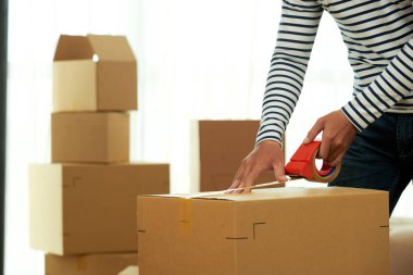 malzeme karton kutu ambalaj ve hareket etmek için viski bant kullanarak adam